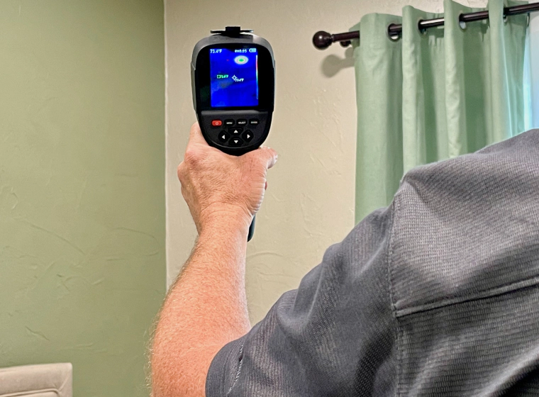 a man holding a device for termites detection