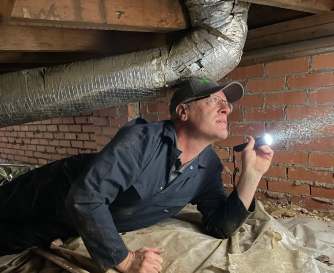 inspector brett smith checking under a house for mold and termites